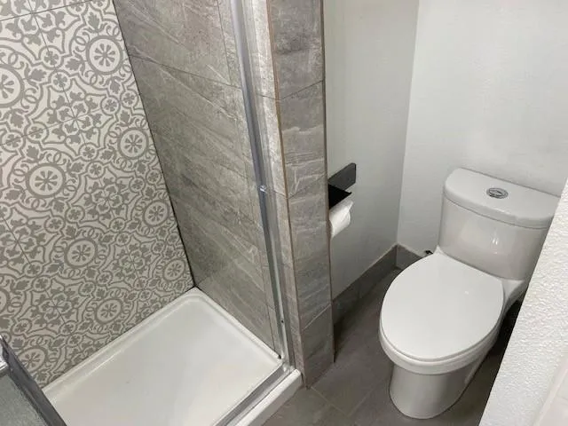 a white toilet sitting next to a shower curtain