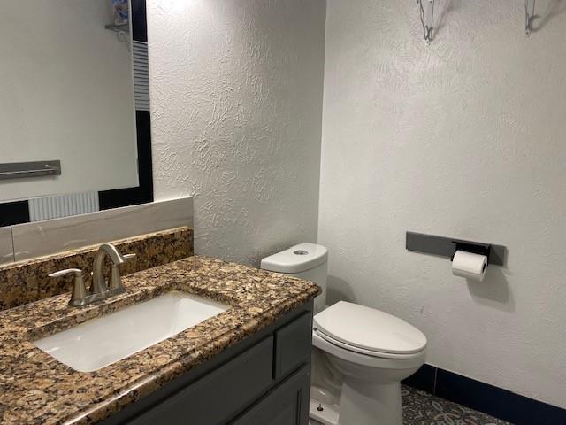 2315 Jimmydee Drive Irving, TX 75060 - Photo 7 of 14 a bathroom with a granite countertop sink a mirror and a toilet