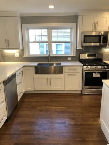 a kitchen with granite countertop a stove a sink and a microwave