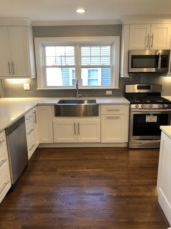 440 Central Avenue, Unit 1 Milton, MA 02186 - Photo 3 of 14 a kitchen with granite countertop a stove a sink and a microwave