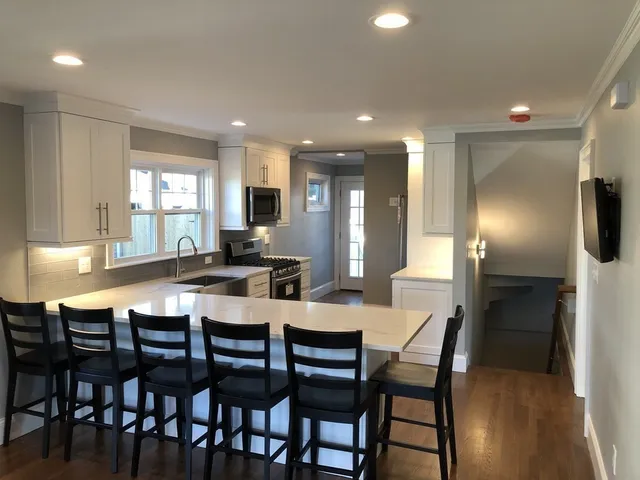 a kitchen with a dining table chairs and refrigerator