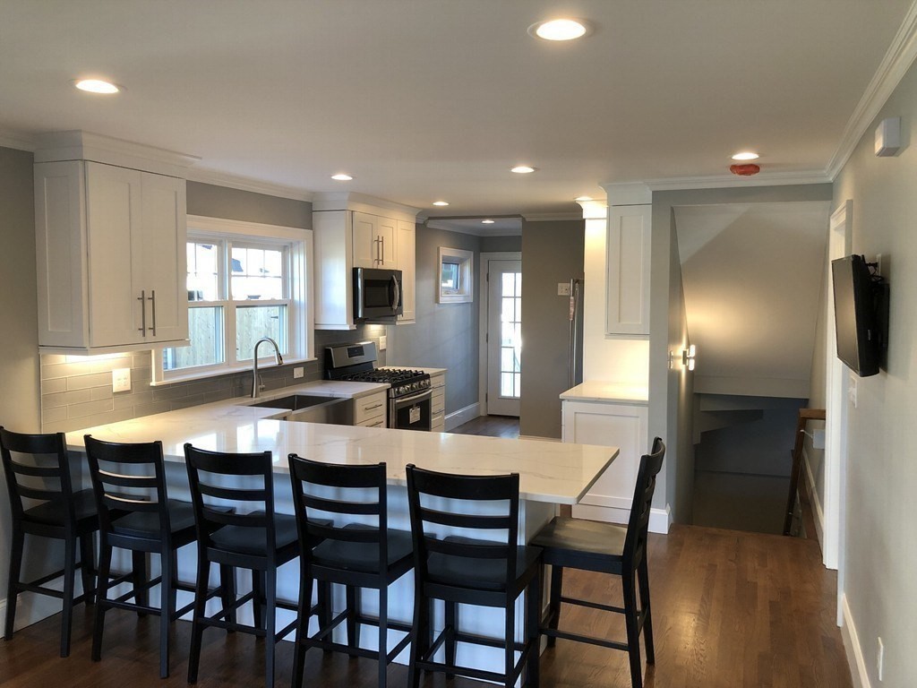 440 Central Avenue, Unit 1 Milton, MA 02186 - Photo 4 of 14 a kitchen with a dining table chairs and refrigerator
