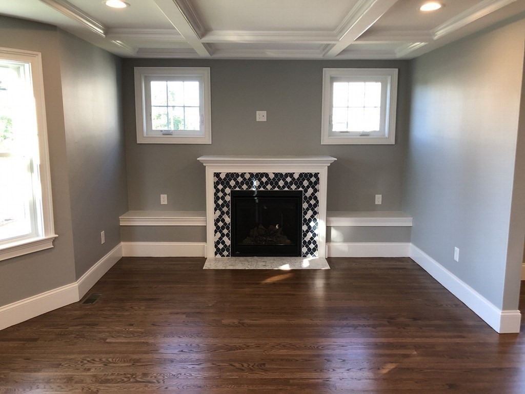 440 Central Avenue, Unit 1 Milton, MA 02186 - Photo 7 of 14 an empty room with wooden floor fireplace and windows