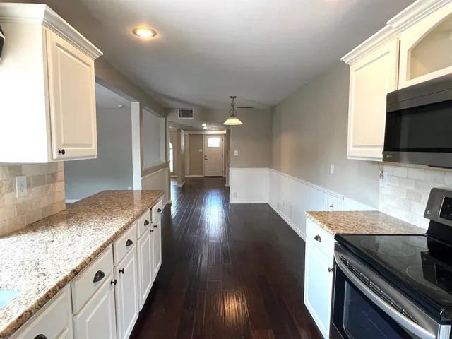 a kitchen with stainless steel appliances granite countertop a stove a sink and a microwave