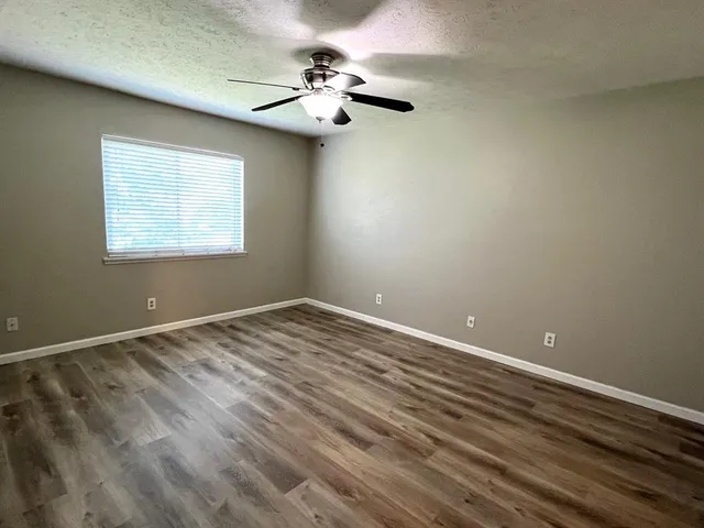 a view of an empty room with a chandelier fan