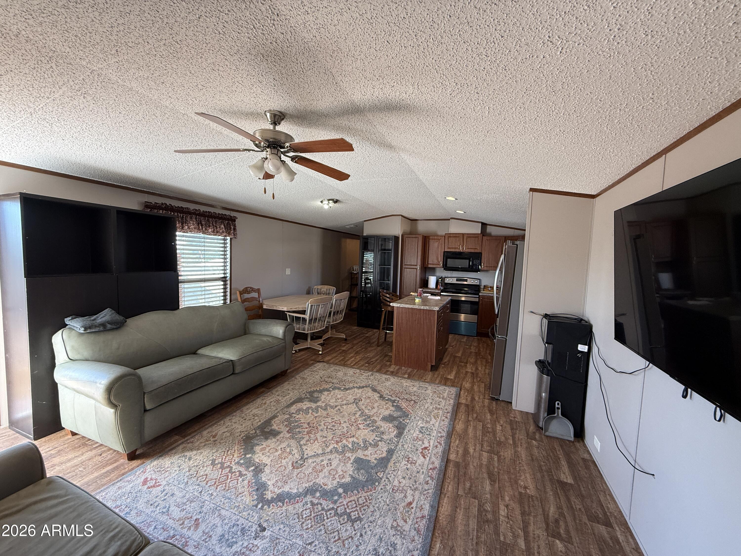 694 South Desert View Drive Apache Junction, AZ 85120 - Photo 8 of 23 a living room with furniture a flat screen tv and kitchen view