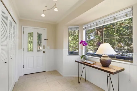 a kitchen with white cabinets appliances a sink and a window