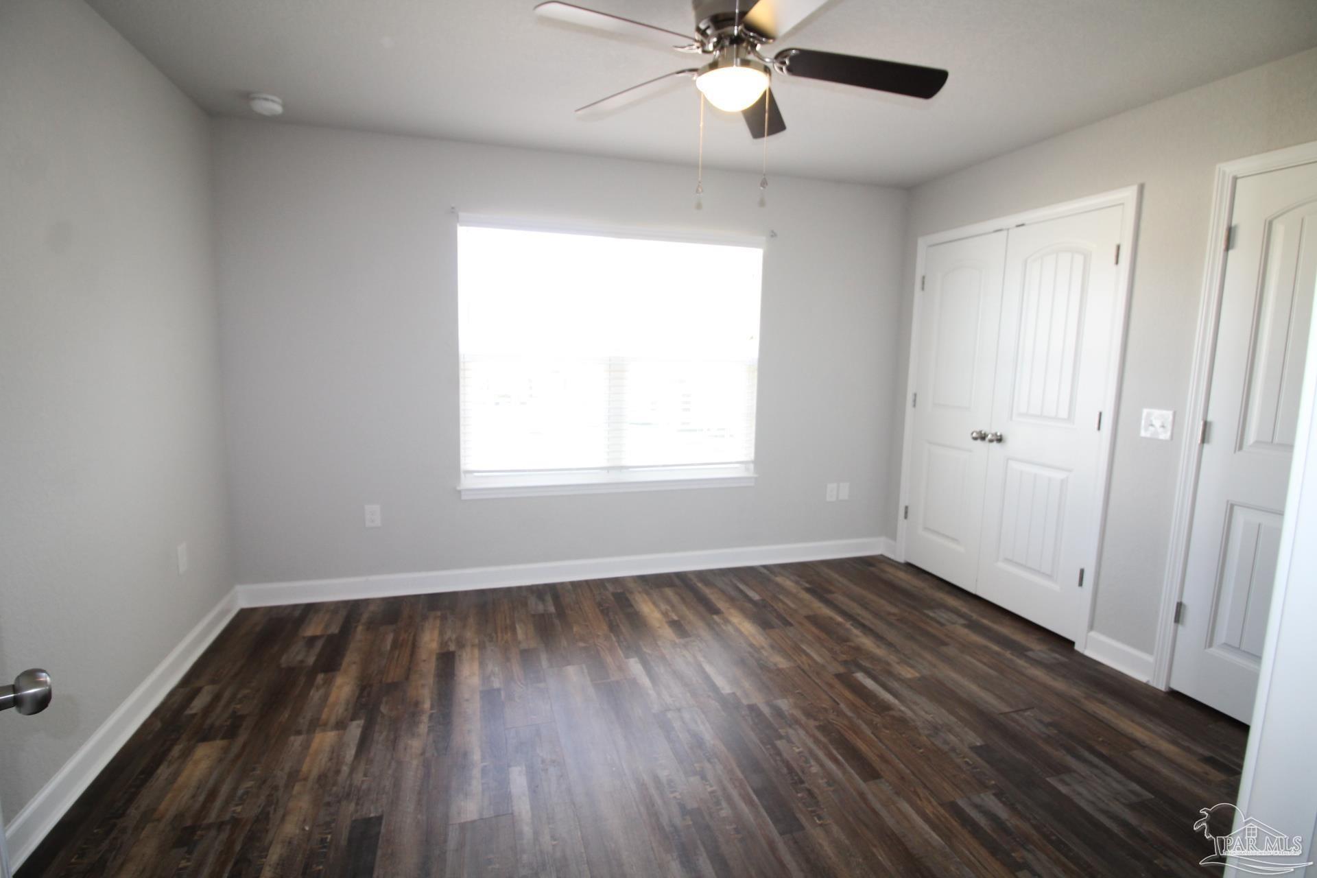 150 South Crow Road, Unit 602 Pensacola, FL 32506 - Photo 6 of 12 a view of an empty room with wooden floor and a window