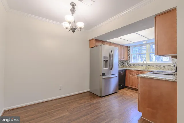 a kitchen with kitchen island wooden floors and stainless steel appliances