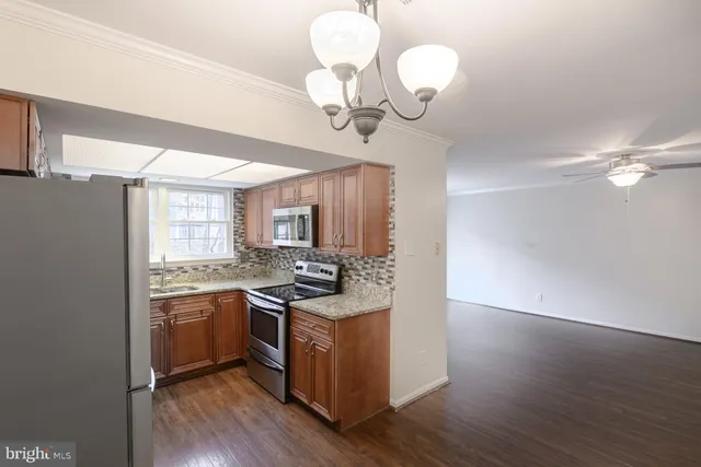 a kitchen with stainless steel appliances granite countertop wooden floors and sink