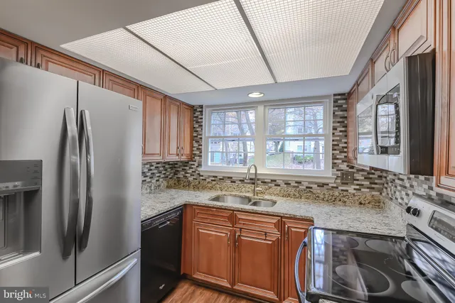 a kitchen with stainless steel appliances granite countertop a refrigerator and a sink
