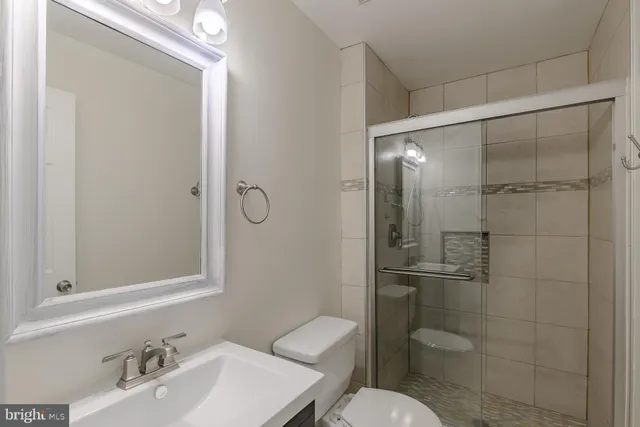 a bathroom with a toilet sink vanity and shower