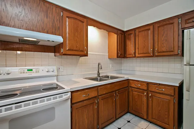 a view of kitchen with stainless steel appliances granite countertop a stove a sink and a window