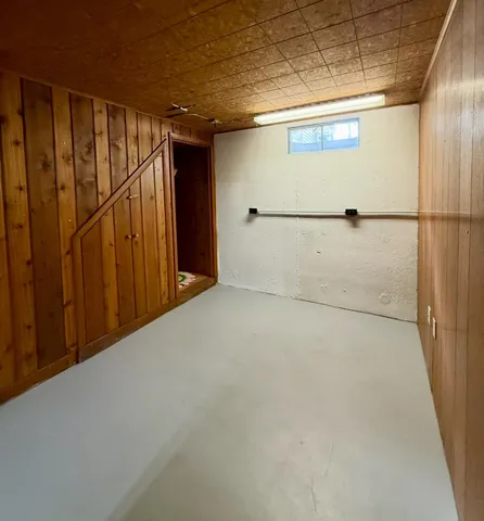 a view of a room with wooden walls and windows