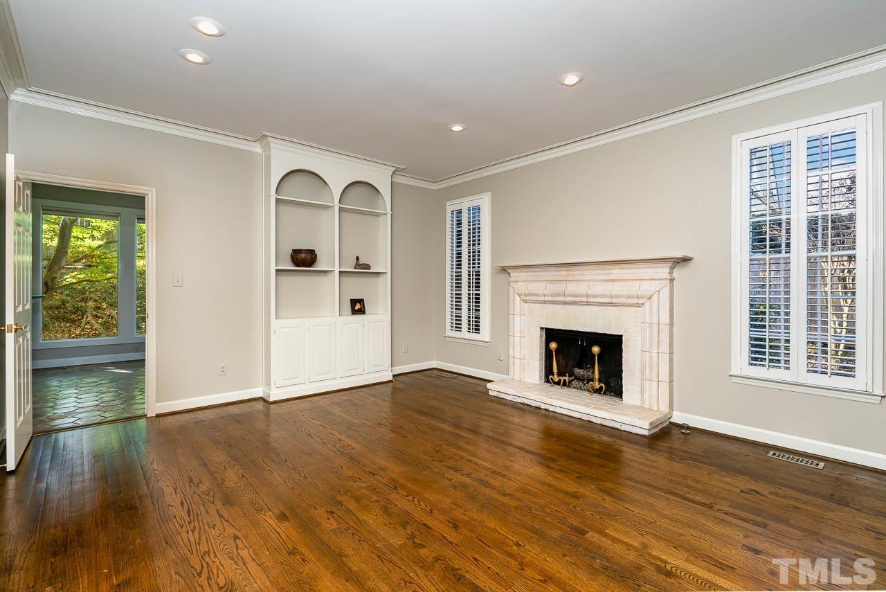 2625 Ashland Street Raleigh, NC 27608 - Photo 13 of 26 a view of an empty room with wooden floor fireplace and a window