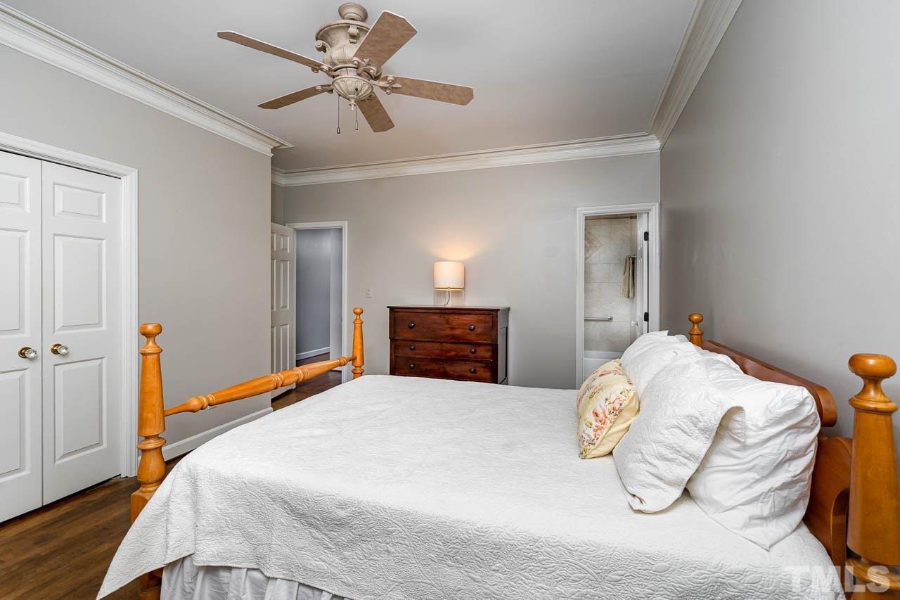 2625 Ashland Street Raleigh, NC 27608 - Photo 16 of 26 a bedroom with a bed and a chandelier