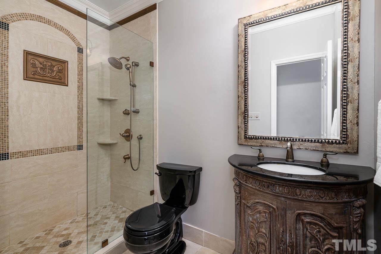 2625 Ashland Street Raleigh, NC 27608 - Photo 22 of 26 a bathroom with a granite countertop sink a toilet and a mirror