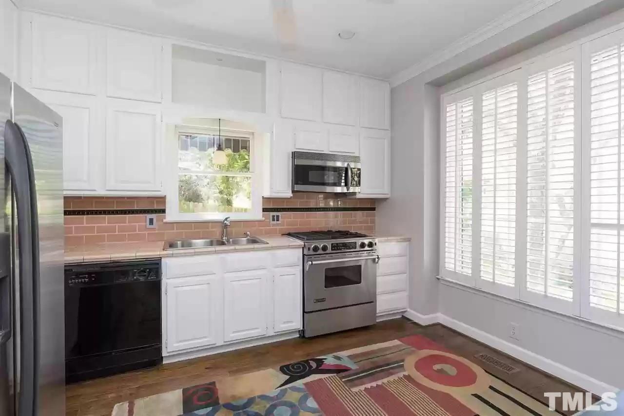 2625 Ashland Street Raleigh, NC 27608 - Photo 3 of 26 a kitchen with stainless steel appliances granite countertop a stove a sink and a microwave
