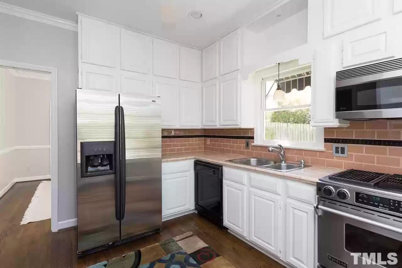 2625 Ashland Street Raleigh, NC 27608 - Photo 4 of 26 a kitchen with stainless steel appliances granite countertop a refrigerator and a stove