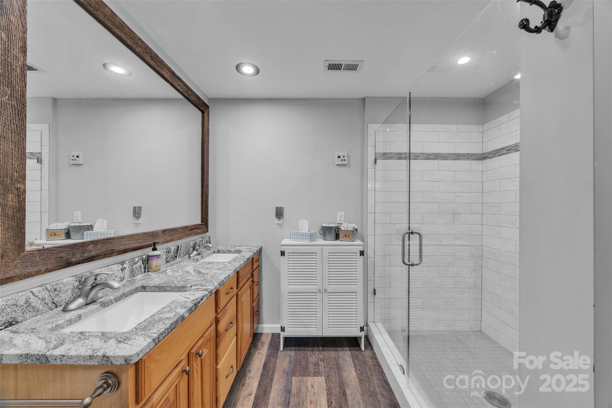5158 Jenkins Road Morganton, NC 28655 - Photo 20 of 40 a bathroom with a granite countertop sink a mirror and shower