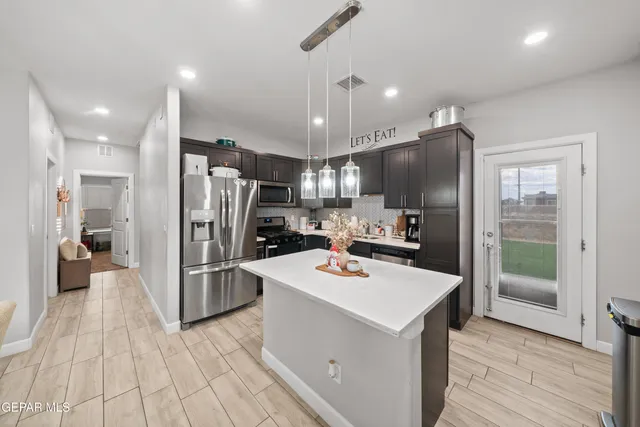 a kitchen with stainless steel appliances a refrigerator sink and microwave