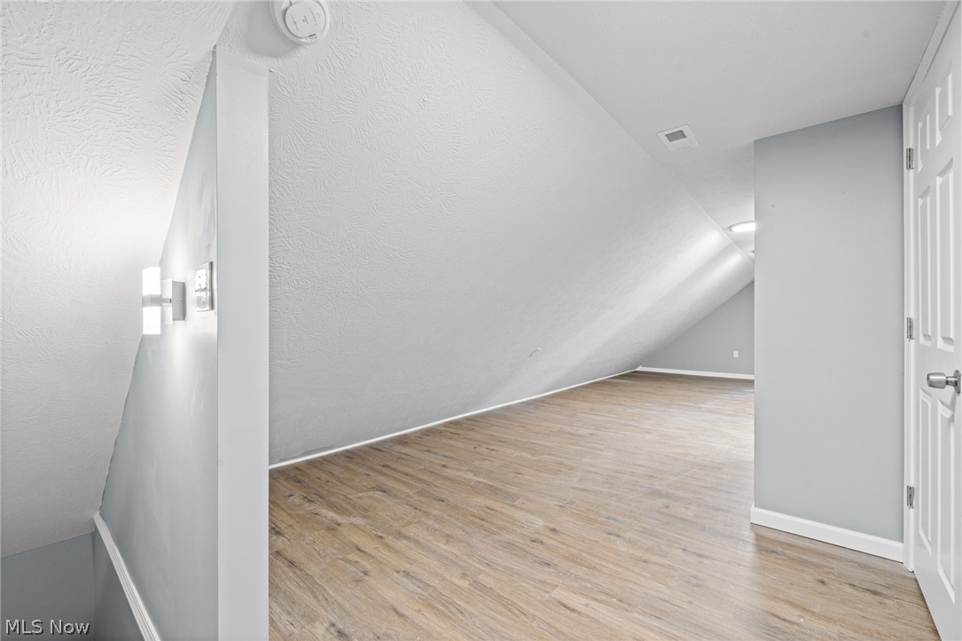 3925 Riverside Avenue Cleveland, OH 44109 - Photo 34 of 48 Attic space with wood-finish flooring, light gray walls, and a white interior door