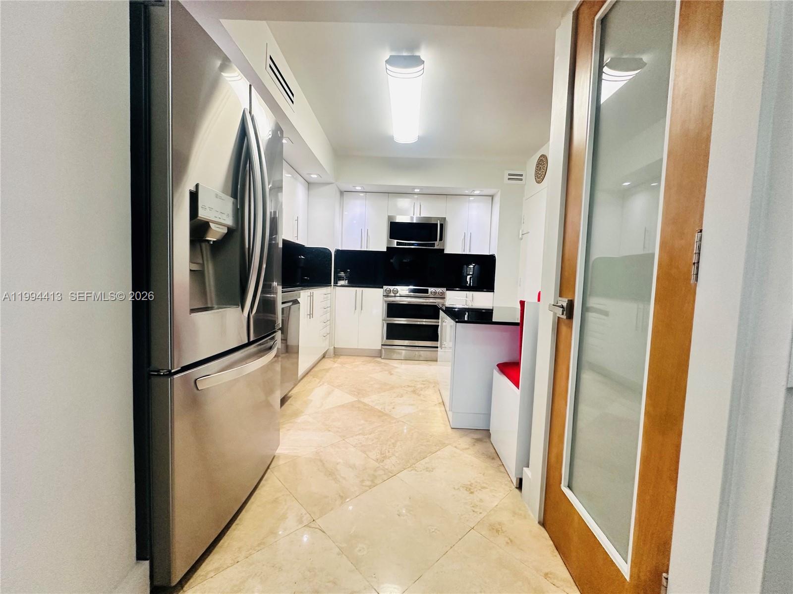 9225 Collins Avenue, Unit 1111 Surfside, FL 33154 - Photo 13 of 54 a kitchen with stainless steel appliances a refrigerator and a sink