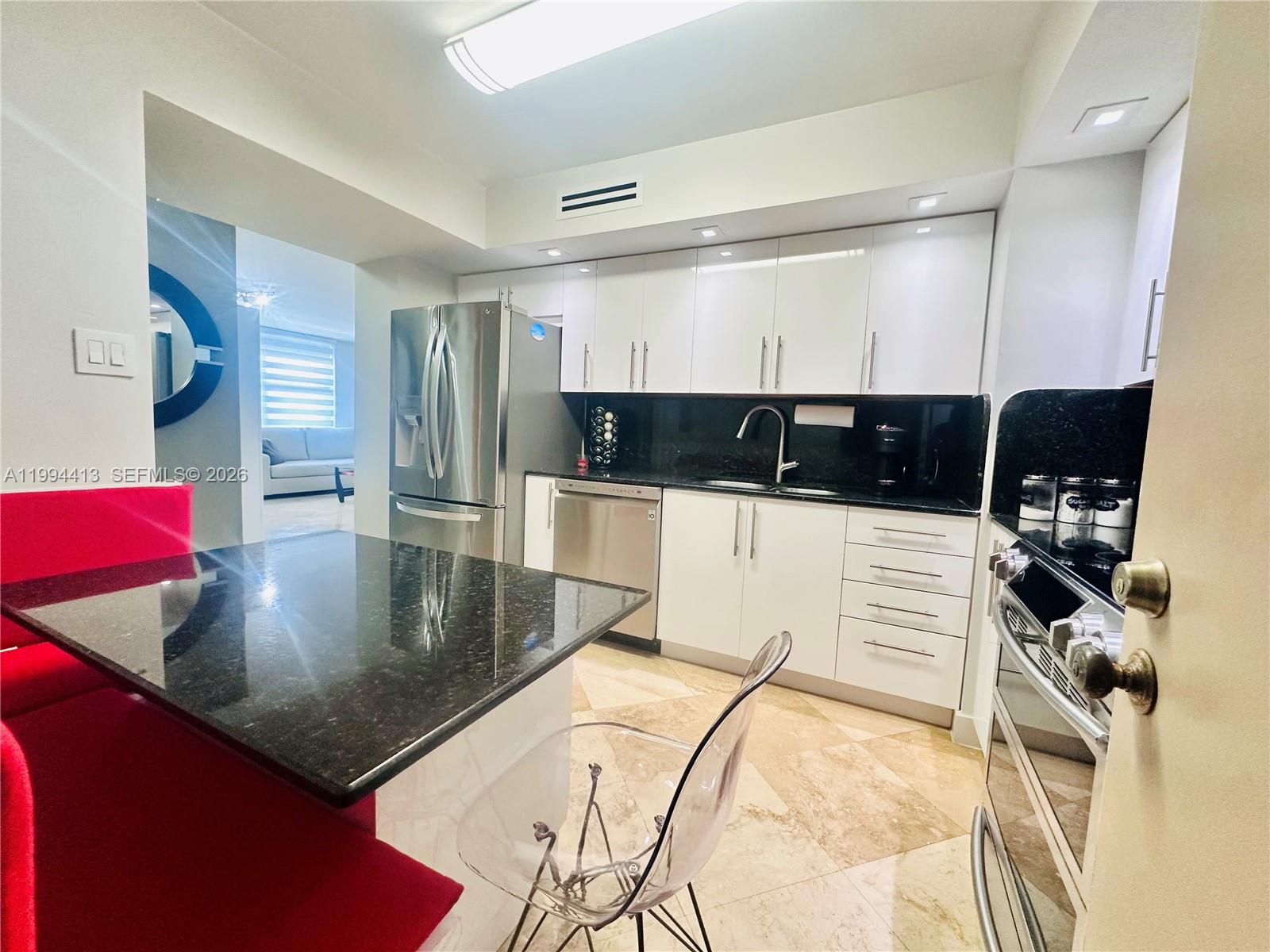 9225 Collins Avenue, Unit 1111 Surfside, FL 33154 - Photo 14 of 54 a kitchen with a sink a counter top space and cabinets