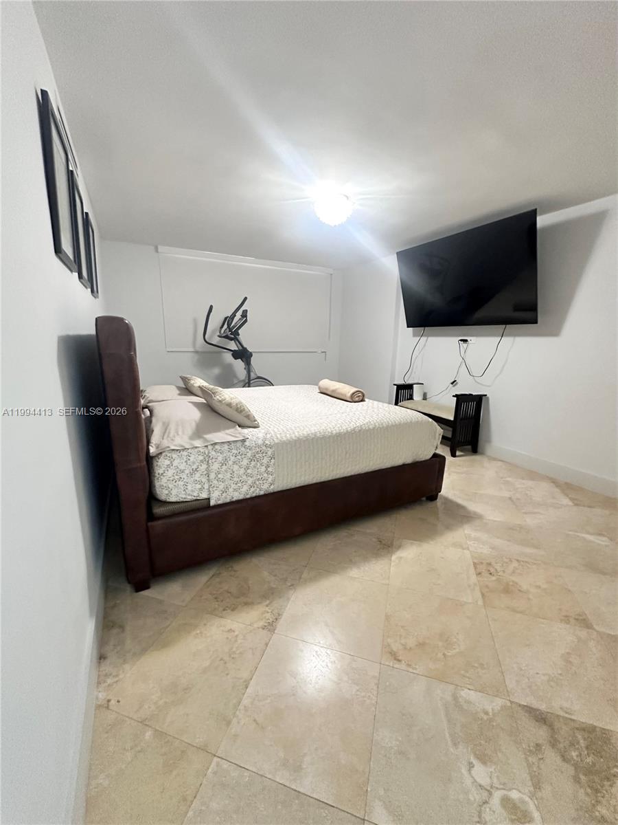 9225 Collins Avenue, Unit 1111 Surfside, FL 33154 - Photo 24 of 54 a bedroom with a bed and a flat screen tv