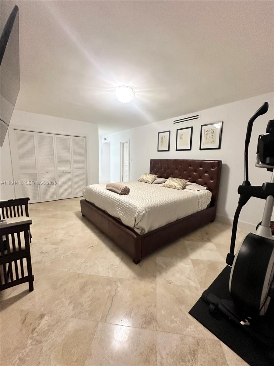 9225 Collins Avenue, Unit 1111 Surfside, FL 33154 - Photo 25 of 54 a bedroom with a bed and dresser