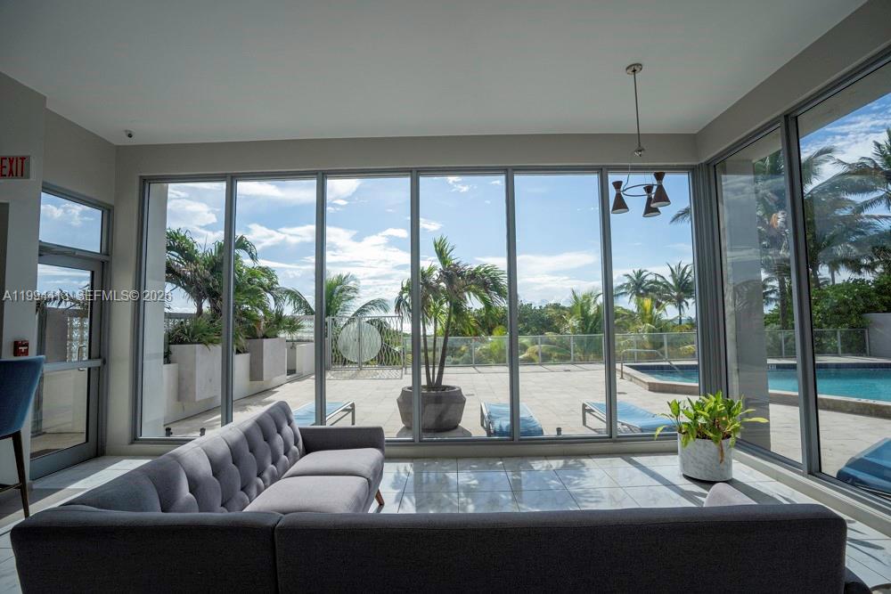 9225 Collins Avenue, Unit 1111 Surfside, FL 33154 - Photo 44 of 54 a living room with furniture and a floor to ceiling window