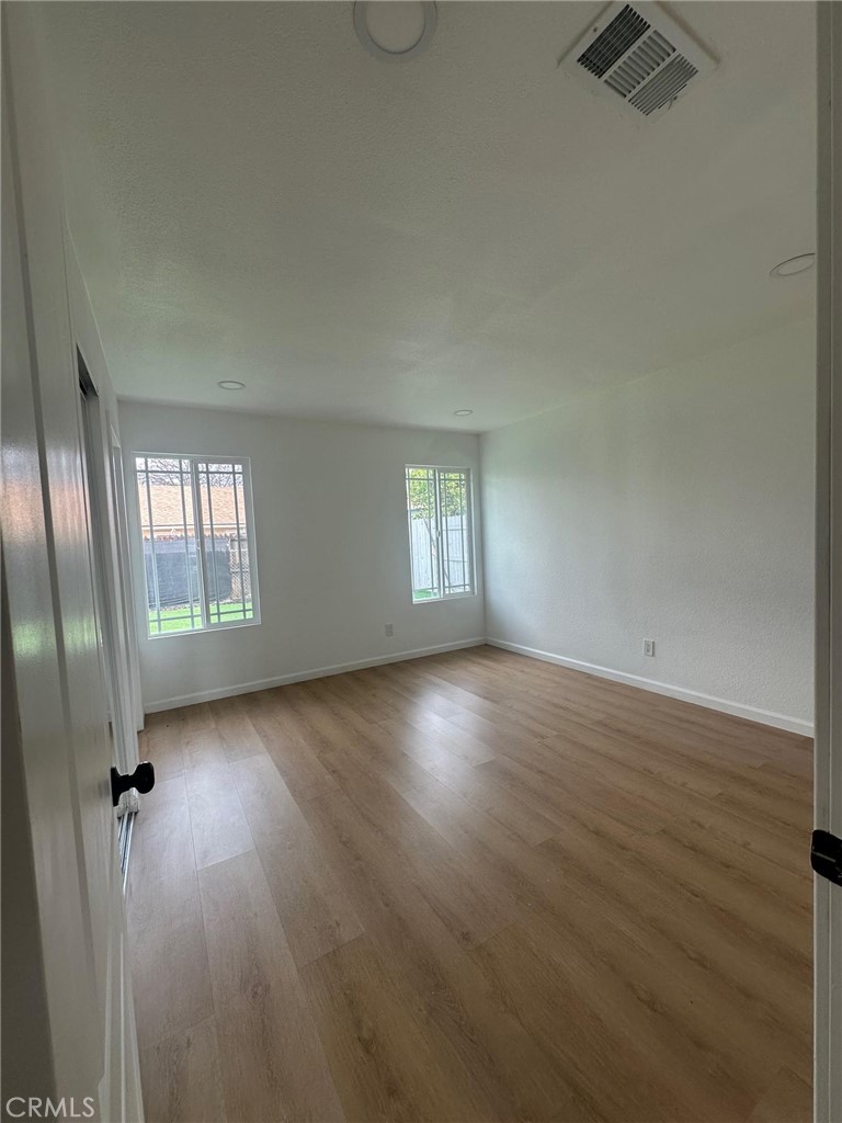 2014 Iris Way Hemet, CA 92545 - Photo 5 of 10 an empty room with wooden floor and windows