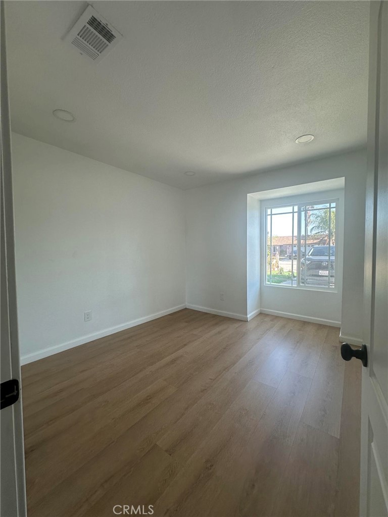 2014 Iris Way Hemet, CA 92545 - Photo 6 of 10 an empty room with wooden floor and windows