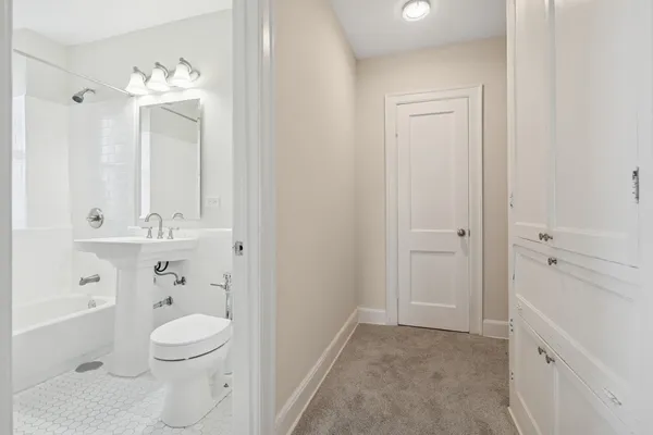 a bathroom with a toilet a sink a mirror a vanity and window