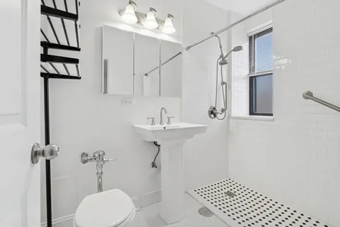a bathroom with a sink a toilet and shower