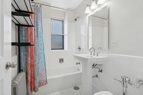 a bathroom with a tub sink and mirror