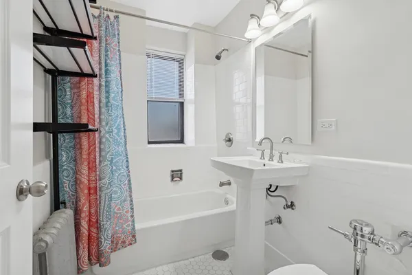 a bathroom with a tub sink and mirror