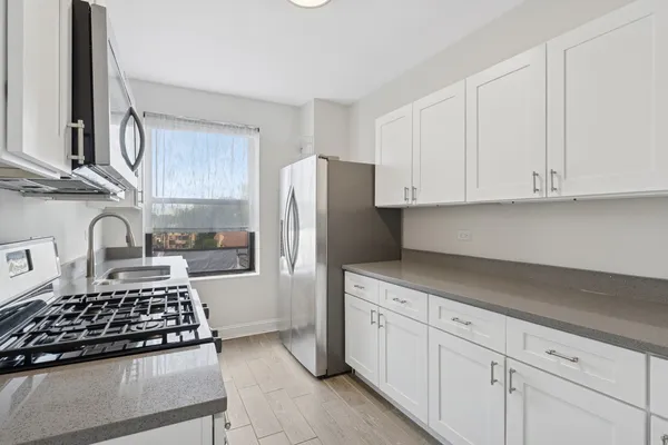 a kitchen with white cabinets and appliances