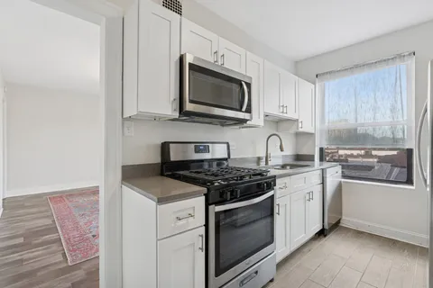 a kitchen with stainless steel appliances granite countertop a stove a sink and a microwave