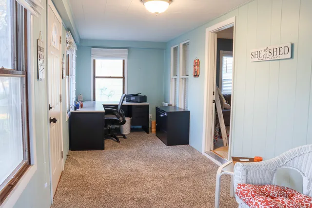a view of a workspace with furniture and a window
