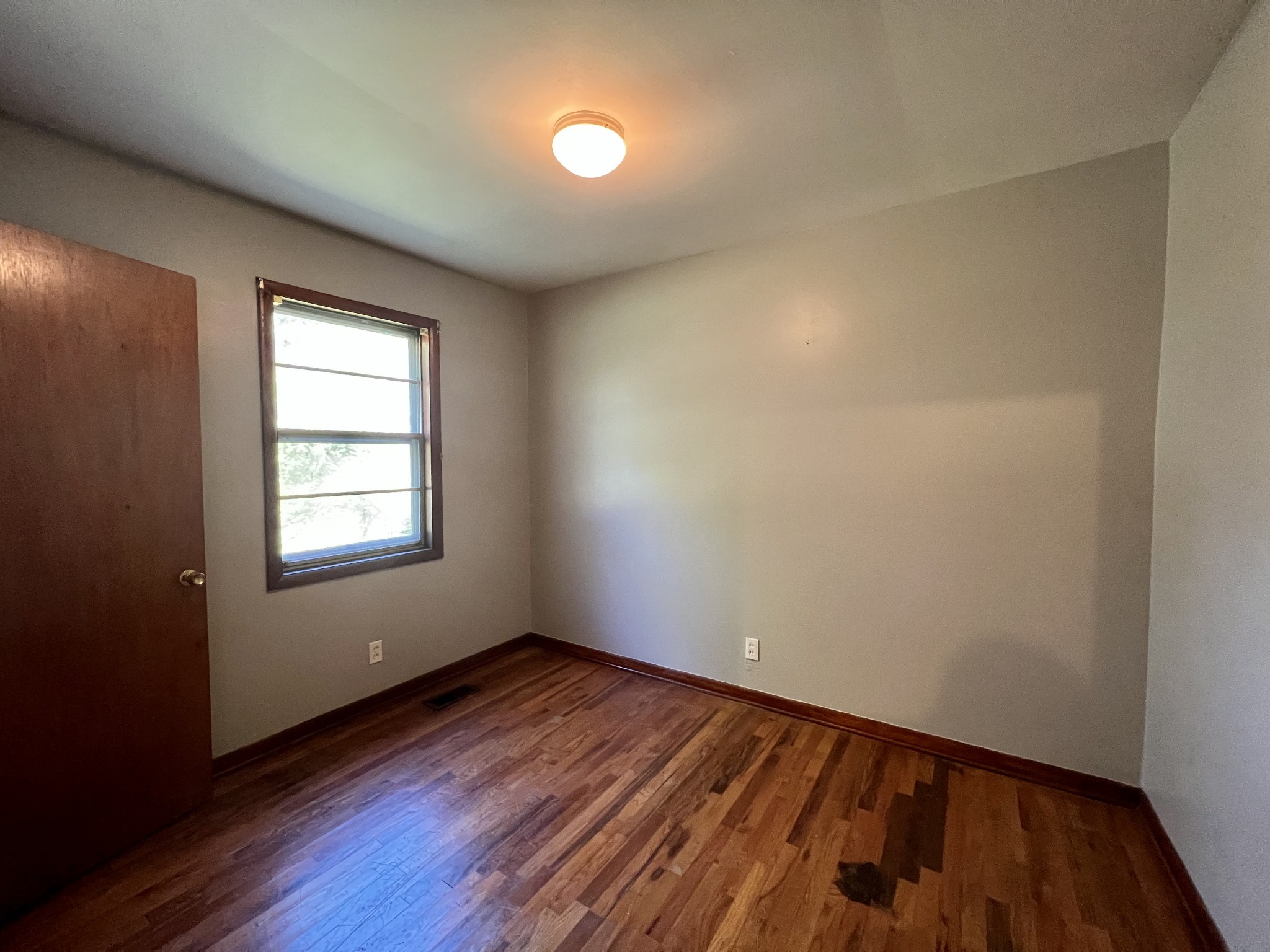 1255 Main Street Pleasant View, TN 37146 - Photo 11 of 14 an empty room with wooden floor and windows