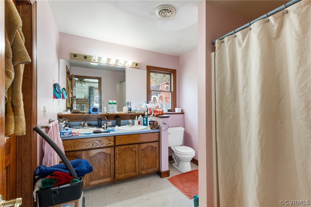 8442 Wheeling Road Mechanicsville, VA 23116 - Photo 15 of 23 a room with a sink a mirror and a shower curtain