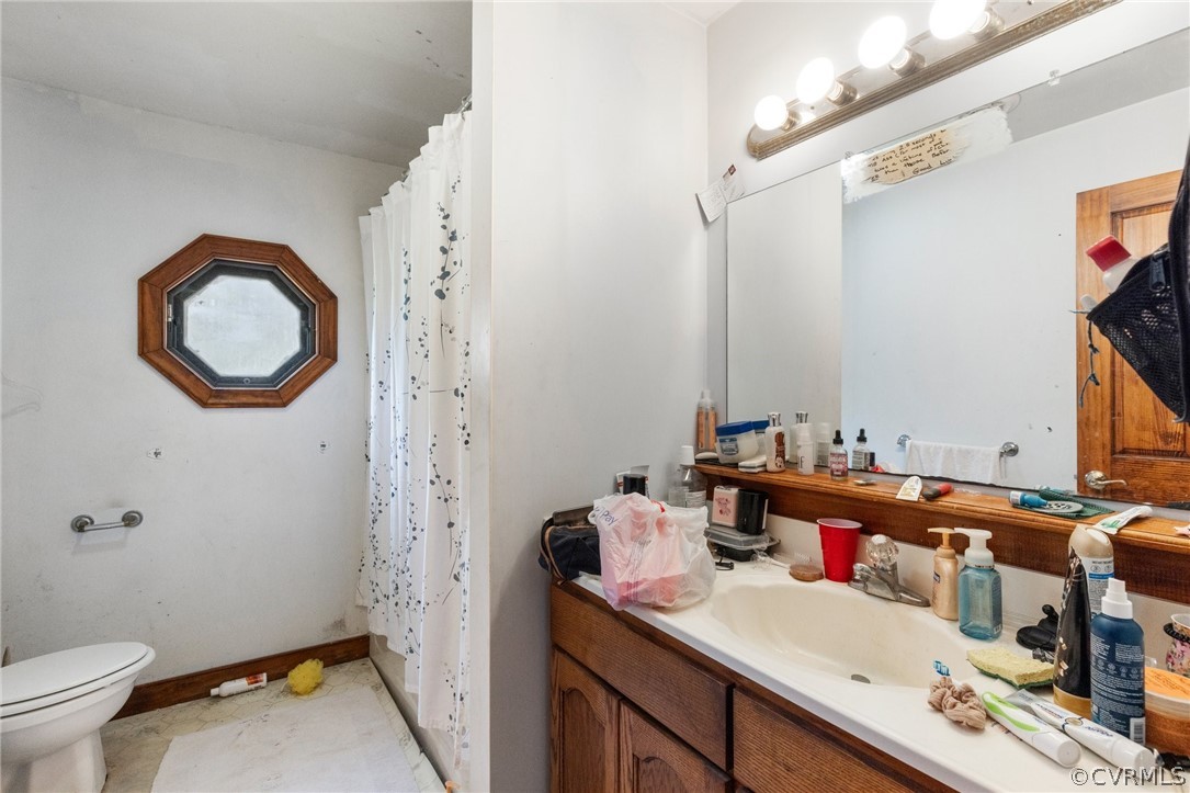 8442 Wheeling Road Mechanicsville, VA 23116 - Photo 17 of 23 a bathroom with a sink vanity mirror and toilet