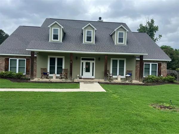 a front view of a house with swimming pool and garden