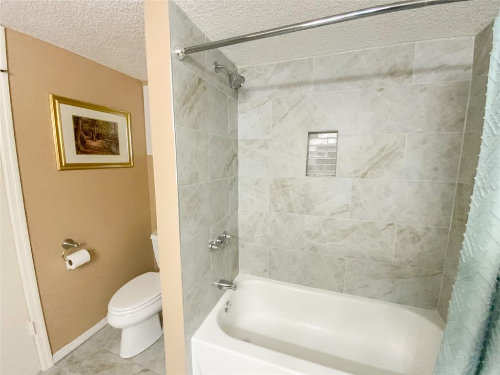 1370 Heather Ridge Boulevard, Unit 204 Dunedin, FL 34698 - Photo 22 of 37 a white bath tub sitting next to a toilet