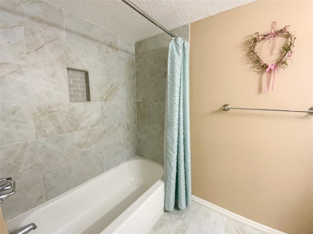 1370 Heather Ridge Boulevard, Unit 204 Dunedin, FL 34698 - Photo 23 of 37 a bathroom with a bathtub and a shower