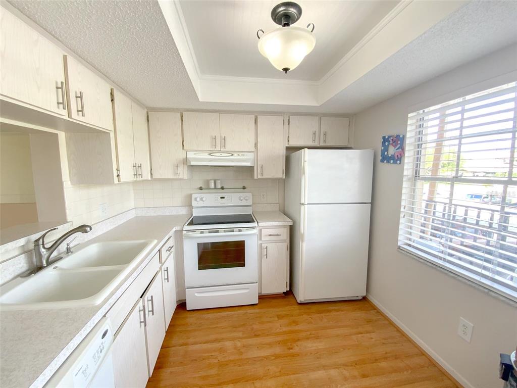 1370 Heather Ridge Boulevard, Unit 204 Dunedin, FL 34698 - Photo 6 of 37 a kitchen with a white cabinets and white appliances