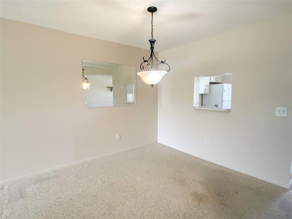 1370 Heather Ridge Boulevard, Unit 204 Dunedin, FL 34698 - Photo 7 of 37 a view of a hallway with a chandelier fan and wooden floor