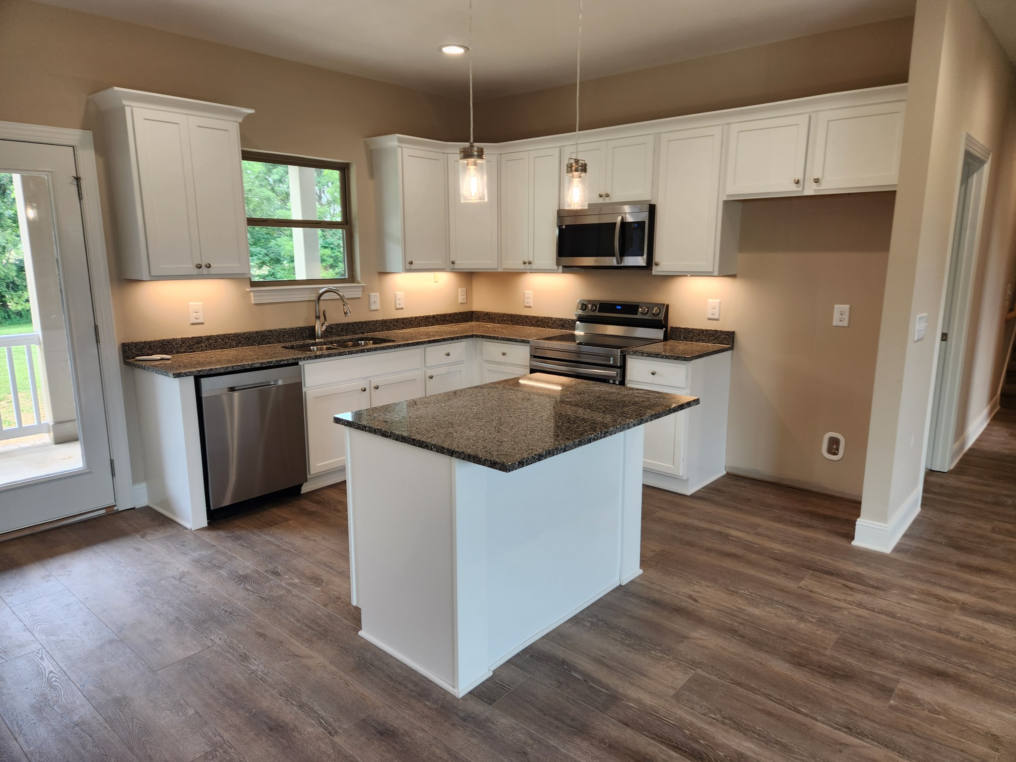 7685 Covington Road White House, TN 37188 - Photo 6 of 17 a kitchen with granite countertop a sink stove and refrigerator