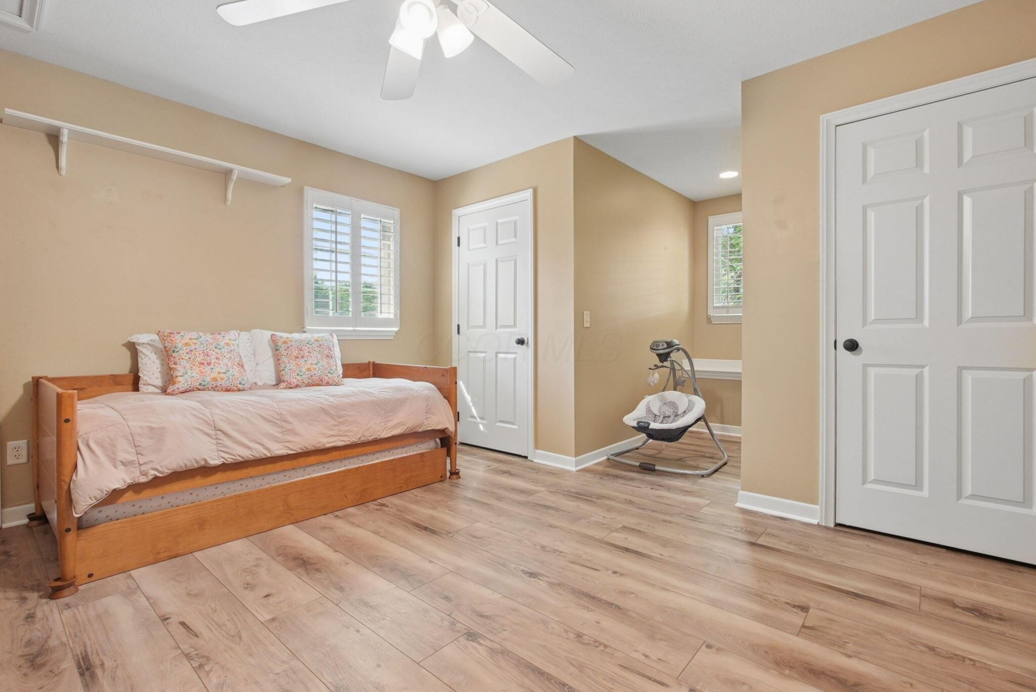 9435 Concord Road Powell, OH 43065 - Photo 35 of 77 Wood-finish flooring, white paneled doors, ceiling fan with light fixture, and white window shutters